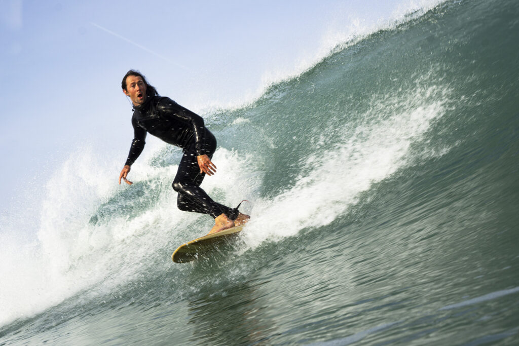 surfing a sustainable, hollow wooden surfboard by Otter Surfboards