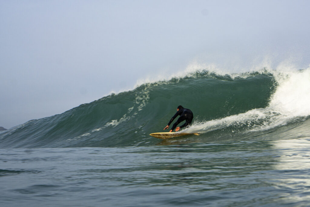 surfing a sustainable, hollow wooden surfboard by Otter Surfboards