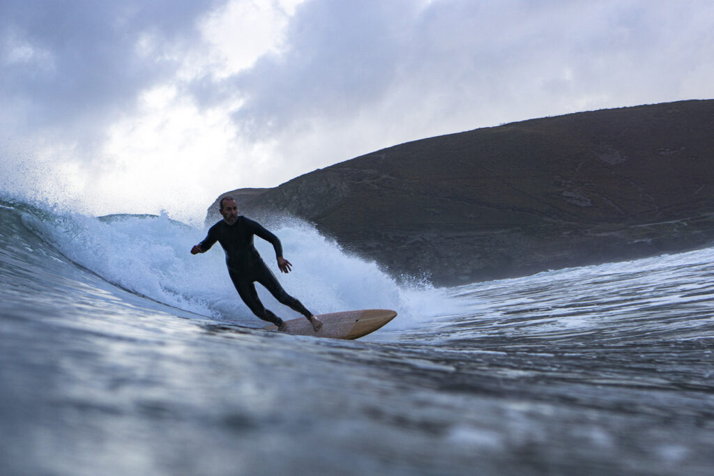Surfer on a Sustainable, Hollow Wooden Surfboard in Cornwall, UK Otter Surfboards