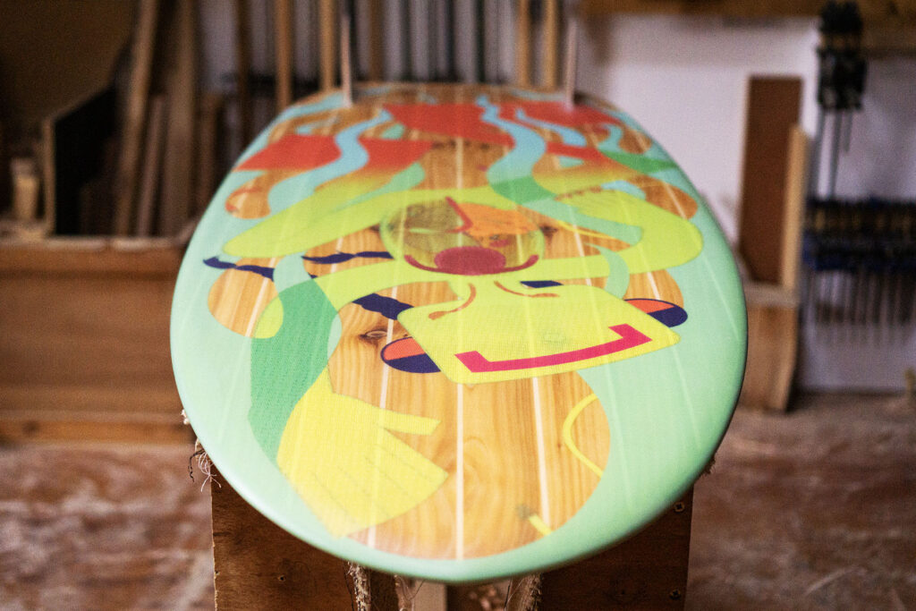 Sustainable, hollow wooden surfboard featuring artwork by Christina Barrera
