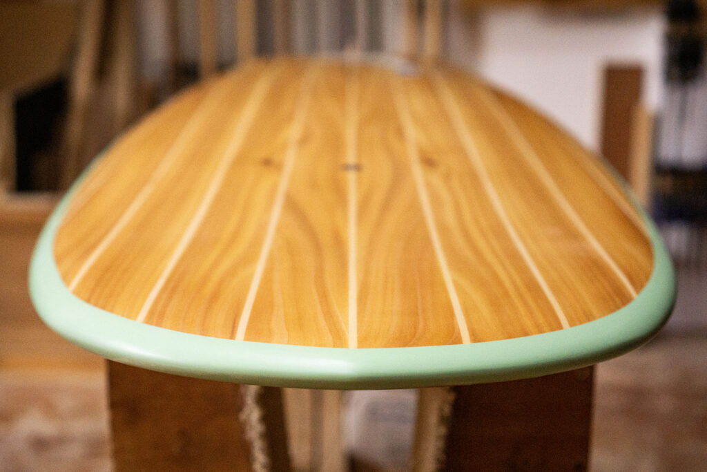 Sustainable, hollow wooden surfboard featuring artwork by Christina Barrera