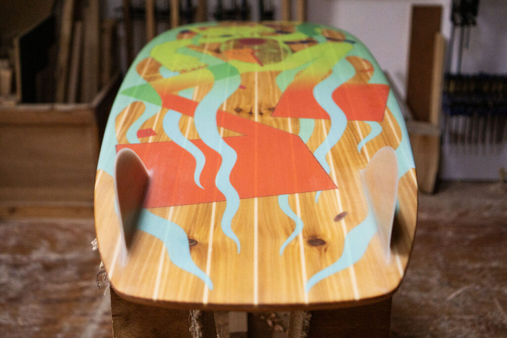 Sustainable, hollow wooden surfboard featuring artwork by Christina Barrera