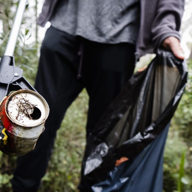 man collecting garbage in the forest