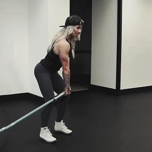 Athlete performing landmine rotational clean, mid-pull with bar sweeping diagonally across body, hips rotating, cinematic gym lighting