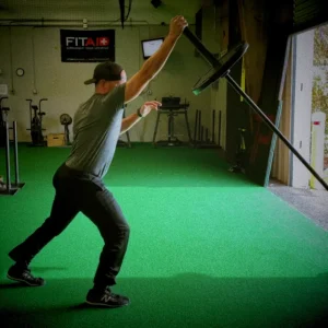 Athlete performing landmine split jerk, barbell angled upward, split stance mid-catch, cinematic gym lighting