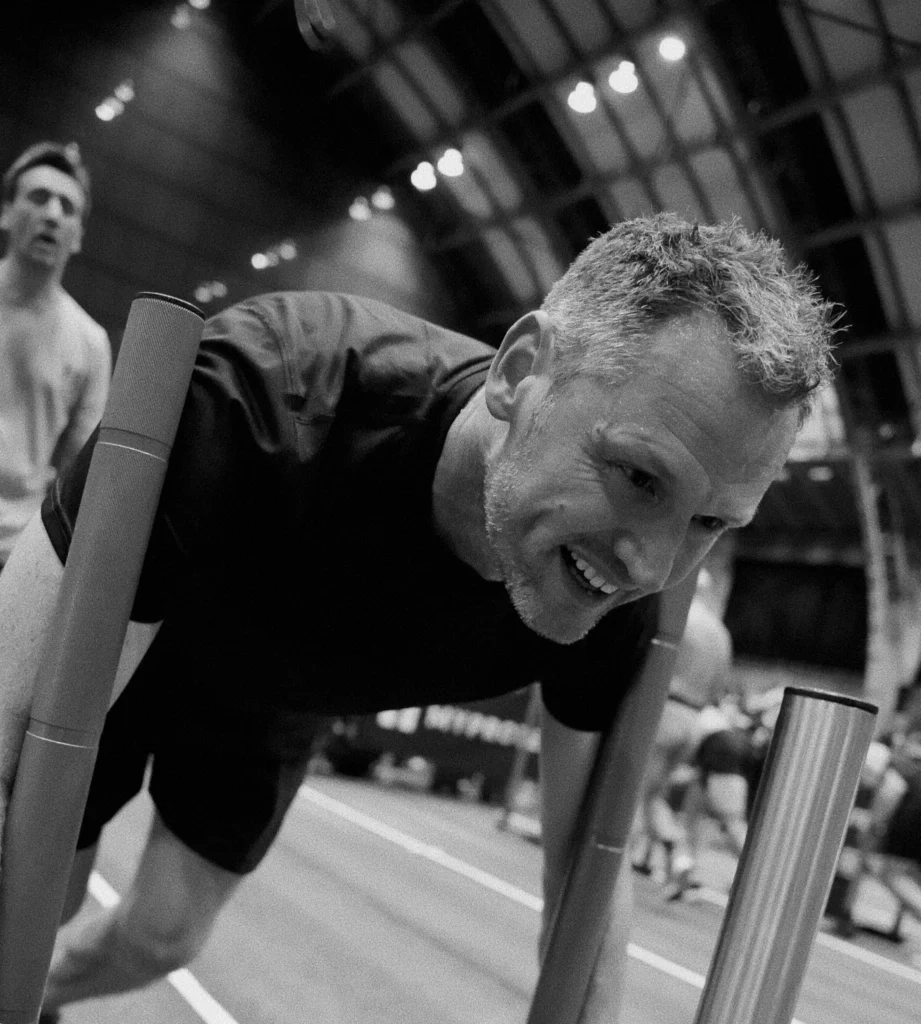 Athlete mid sled push big smile on face