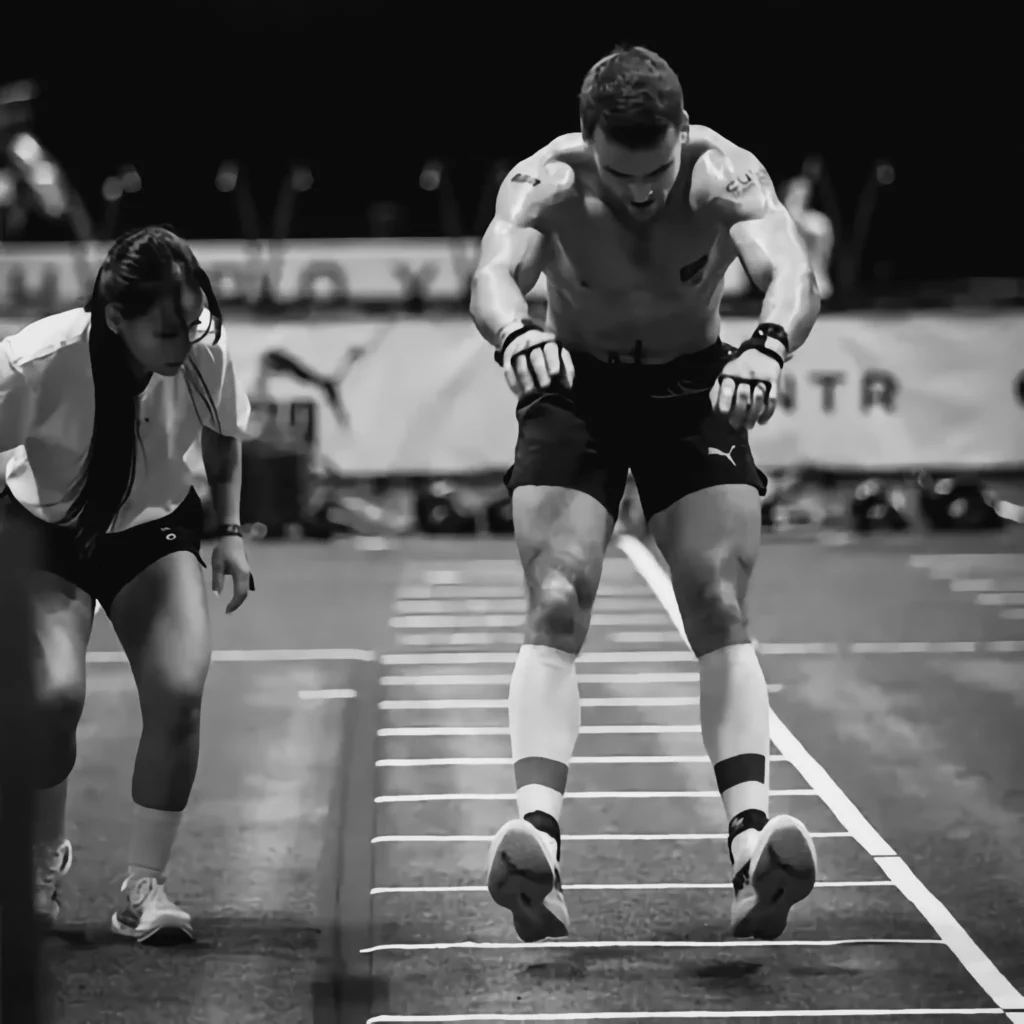 Athlete landing from burpee broad jump, chest upright, arms forward