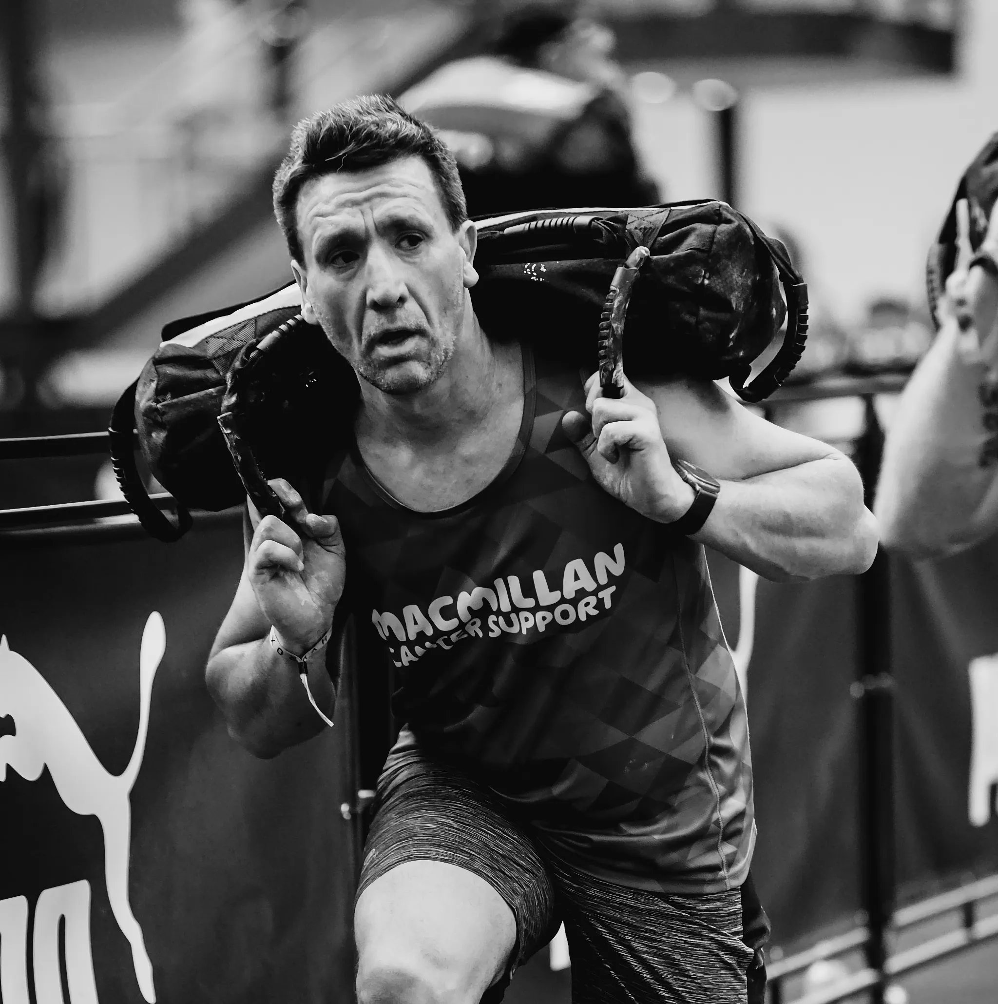 Athlete mid-lunge with sandbag across shoulders, front knee 90°, upright posture