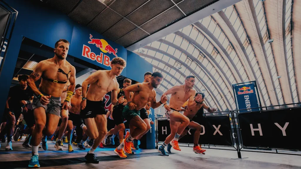 Athlete standing still amid a busy HYROX start pen, calm expression