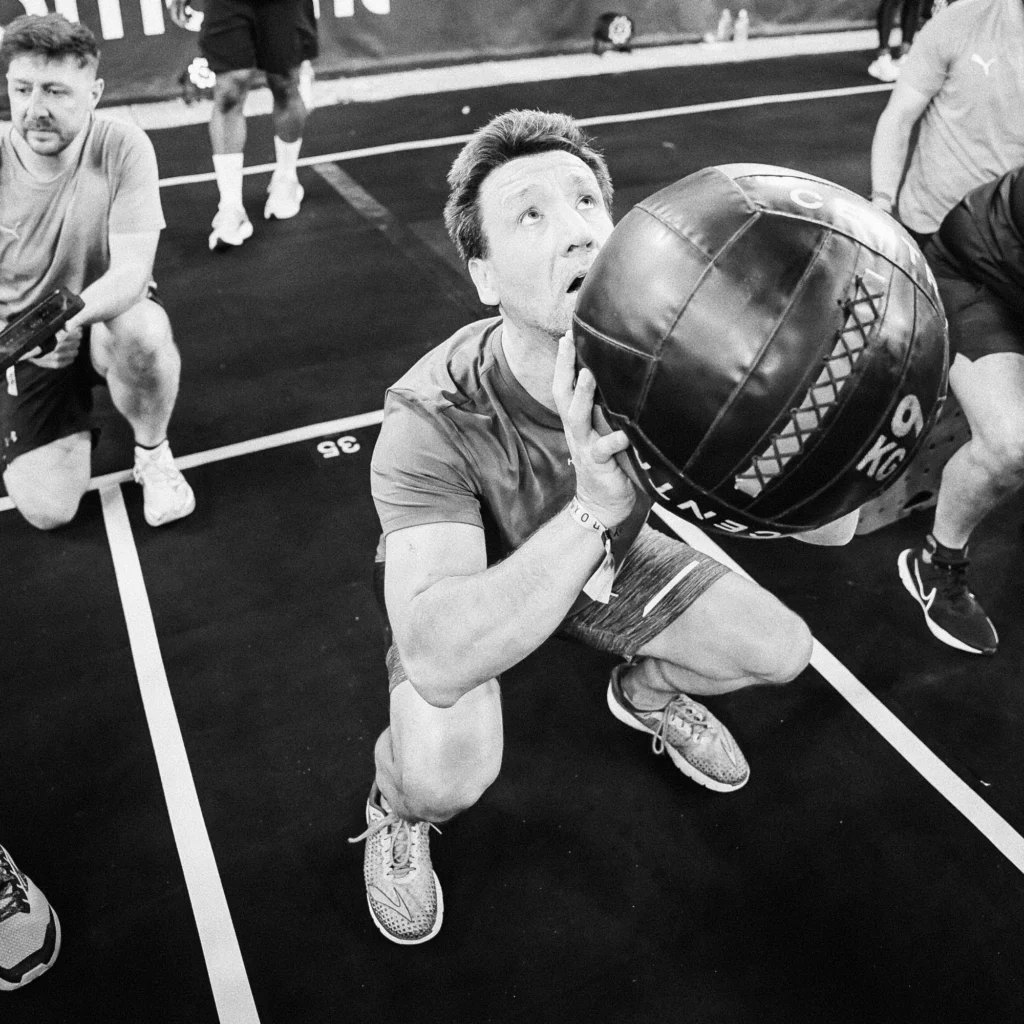 Two athletes alternating wall ball sets