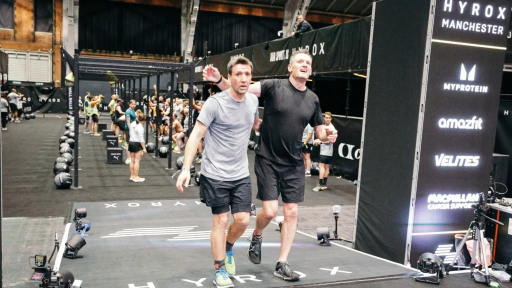 HYROX arena crowd cheering athletes crossing the finish line