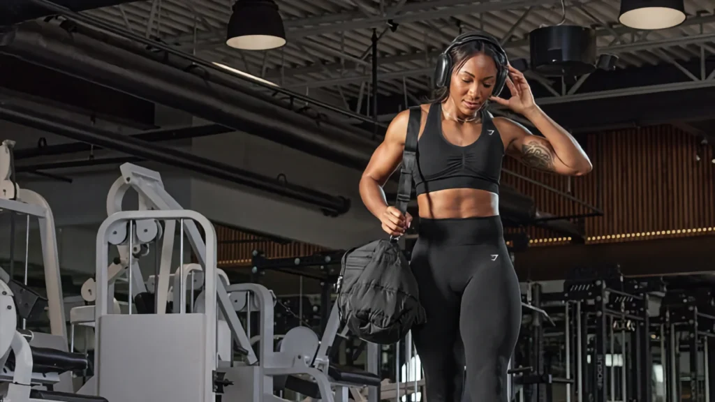 athlete walking through gym with gym bag on shoulder