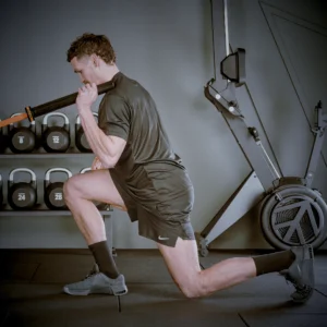 athlete performing a landmine reverse lunge to press