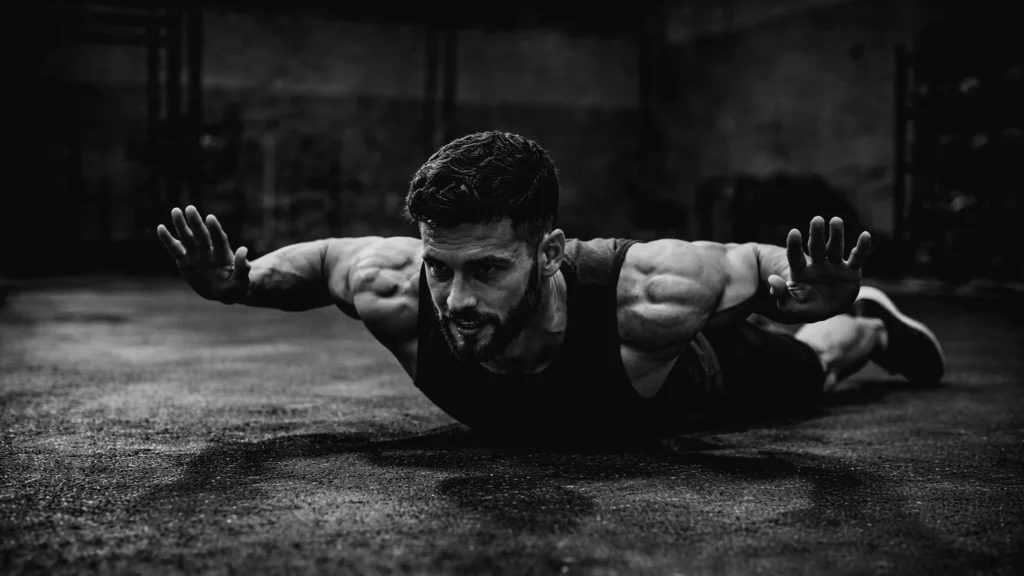 Athlete at the bottom position of a hand-release push-up, chest on floor