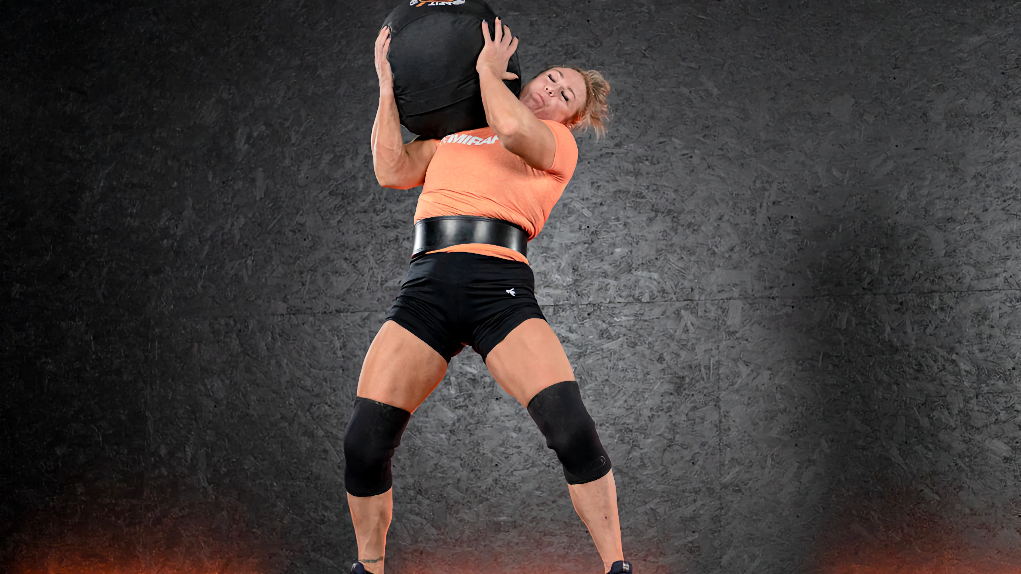 Athlete mid-shoulder toss with a heavy slam ball, powerful hip extension