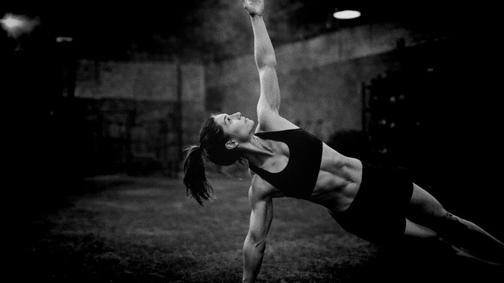 Athlete in top side plank position, arm extended vertically