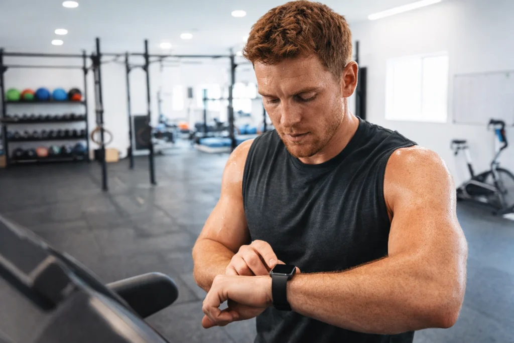 Athlete checking a smartwatch after a treadmill interval