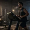 Dark industrial gym environment at early morning light. Athlete moving steadily on a treadmill while another rows in the background
