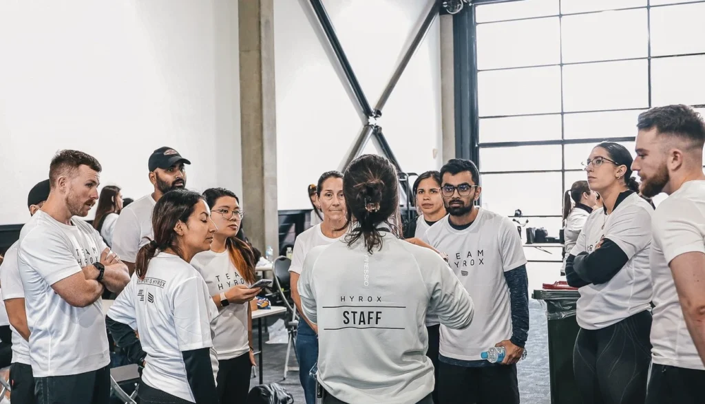Volunteer briefing before race start, clipboards and radios visible