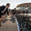 Riders in smart jackets sprint towards rows of folded Brompton bikes for the famous Le Mans-style start, energetic but premium cycling photography, London sporting atmosphere