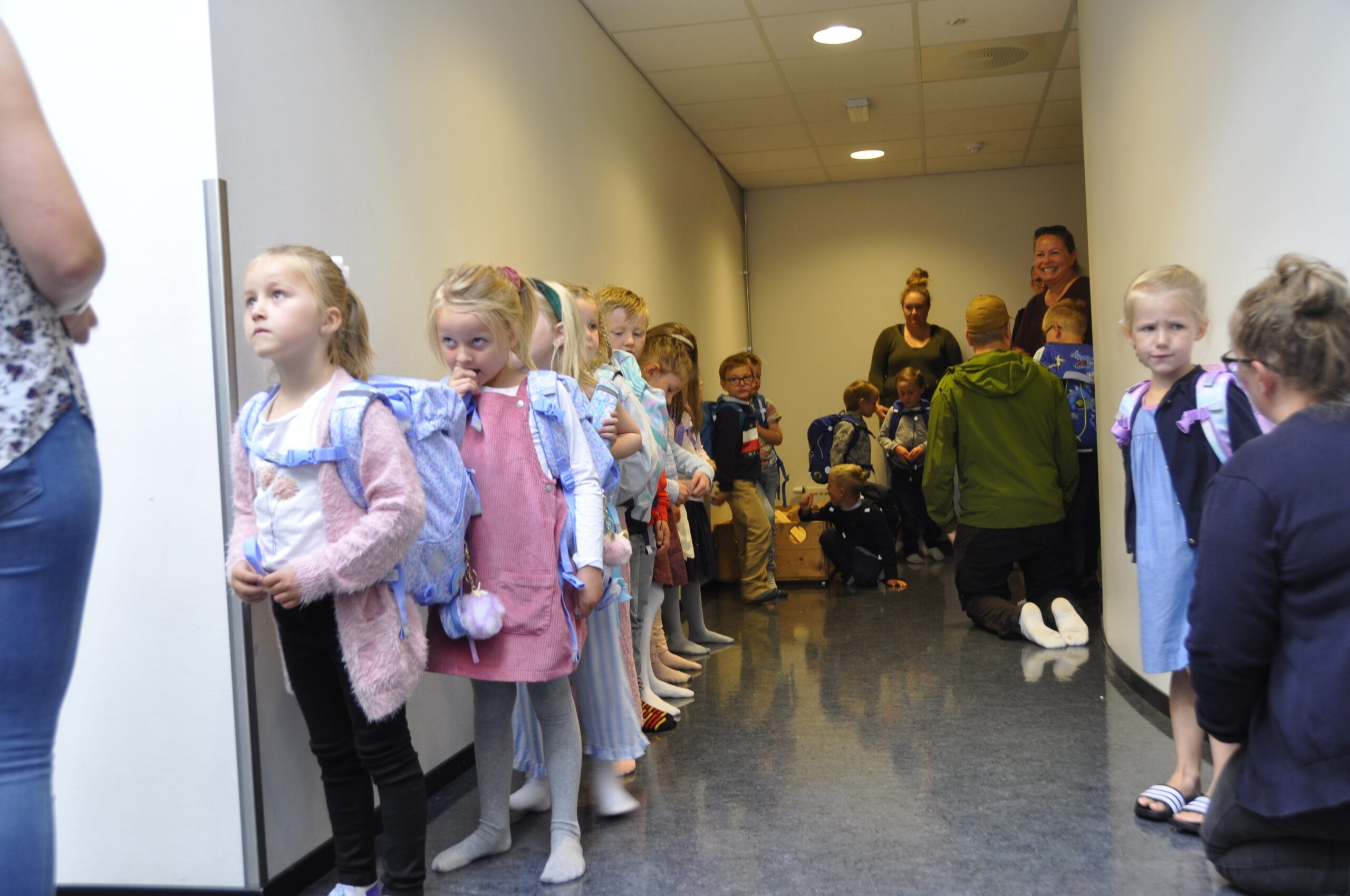 Spente elever står og venter på å innta klasserommet sitt.