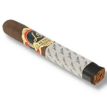 Las Villas By the Book Toro single cigar photographed diagonally on a white background, showing a dark brown wrapper, ornate black, gold and red Las Villas band, white sleeve printed with repeating black Las Villas signature
