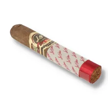 as Villas Selección Box Pressed Robusto single cigar photographed diagonally on a white background, showing its dark brown wrapper, squared body, ornate burgundy and gold Las Villas band, white signature-printed protective sleeve