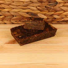 Samuel Gawith Grousemoor Plug loose pipe tobacco showing a dark pressed block of Virginia tobacco with a freshly cut slice revealing the densely layered leaf.