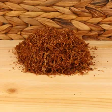 A small pile of light hand rolling tobacco on a wicker and wood background