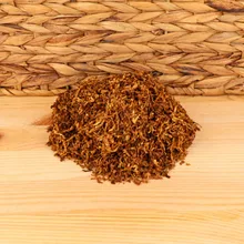 A small pile of shag tobacco on a wooden background