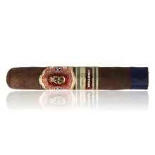 Crowned Heads Broadway Epicure cigar displayed horizontally against a white background with a soft reflection, showing its dark brown Connecticut Broadleaf wrapper, ornate red and gold Crowned Heads band, separate Broadway band and dark blue ribbon