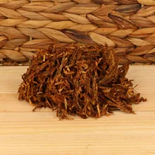 Close-up of Samuel Gawith Full Virginia Ready Rubbed loose pipe tobacco showing dark brown broken-flake pieces and strands of pressed Virginia leaf.