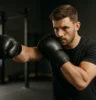 Person practicing boxing or martial arts in a gym, mid-strike or holding a strong guard, with confident posture and focus.