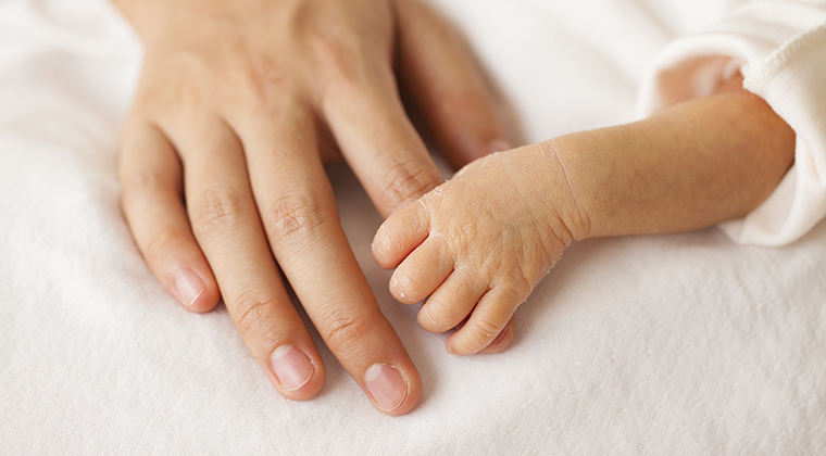 Baby hands and the hands of his mother.
