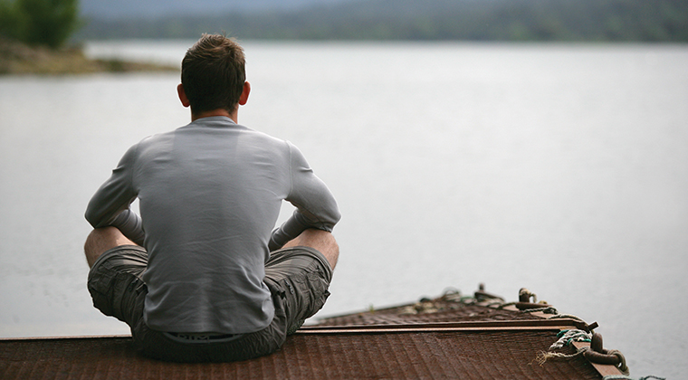 man looking across the water