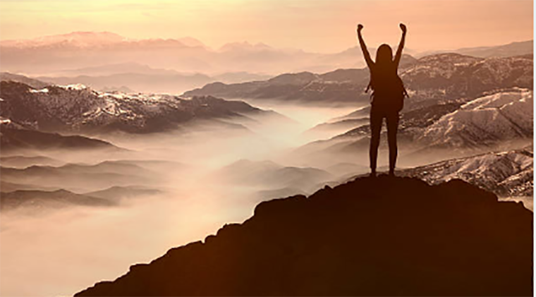 woman on a mountain watching sunset