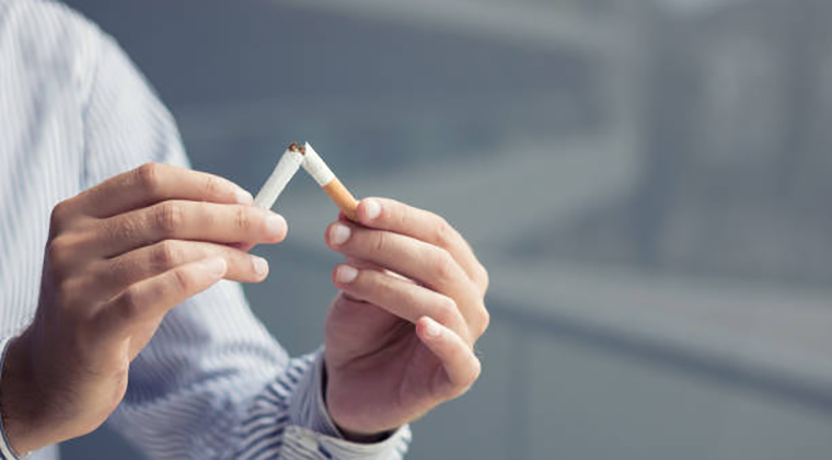 Man breaking cigarette in half. quit smoking