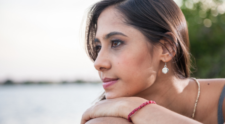 Woman resting chin on hands, gazing and thinking