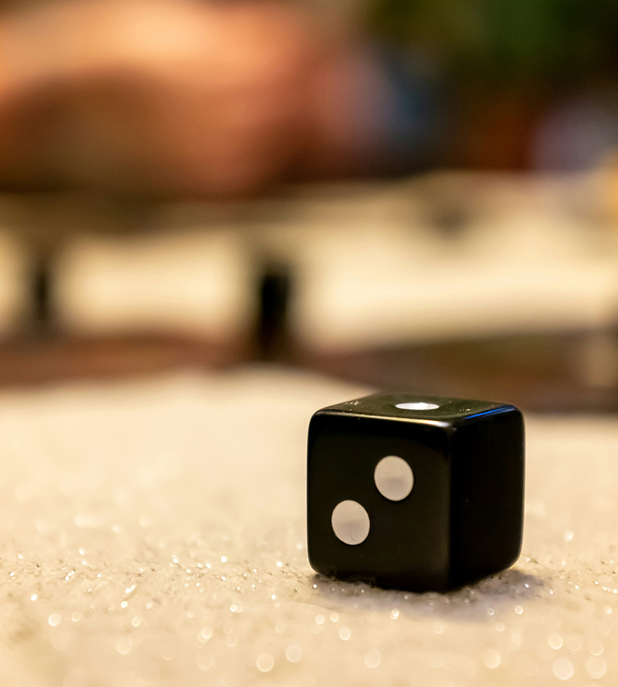 Dice in foreground showing 2 dots, bokeh background