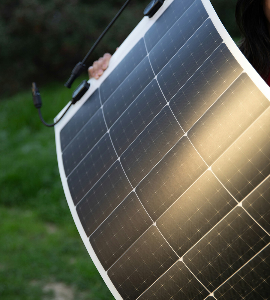 Flexible solar panel being held in a fileld