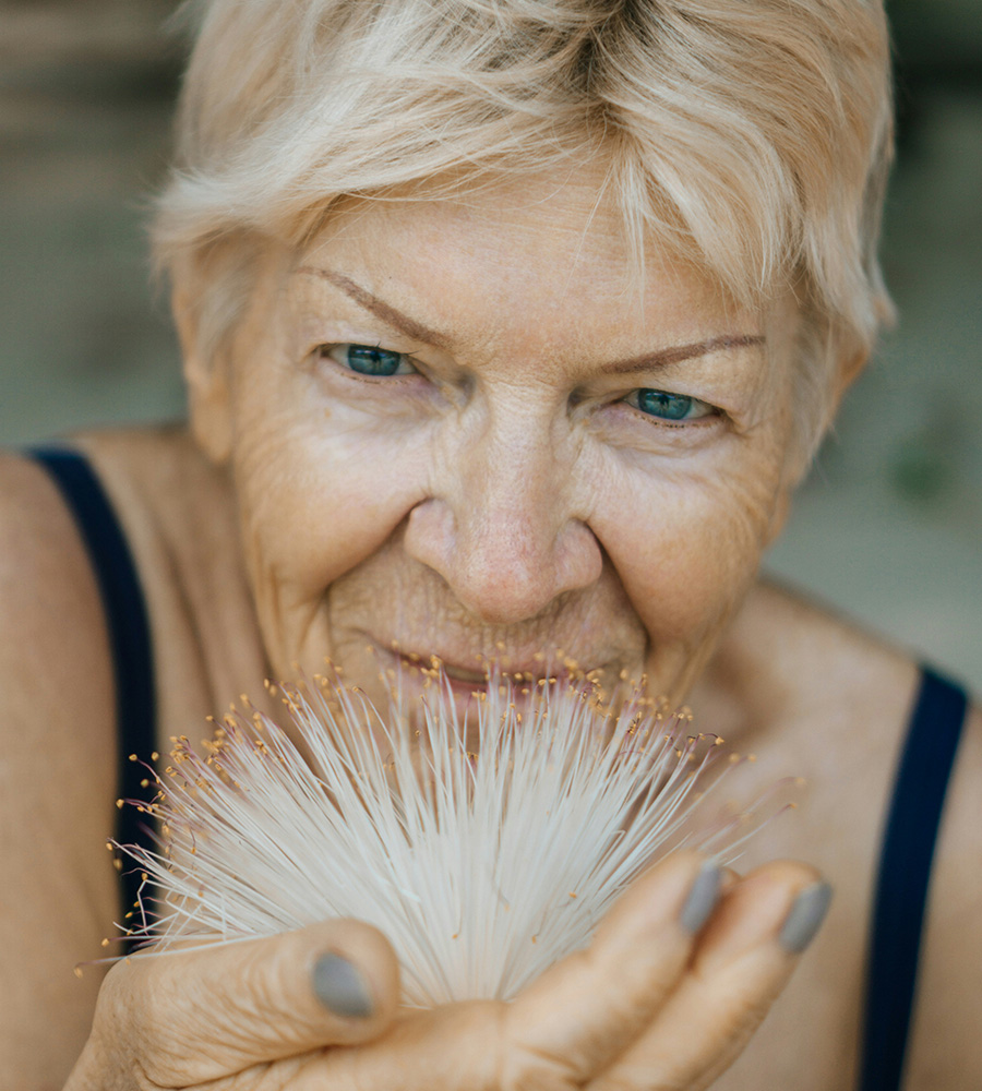 women holding white-petalled flower