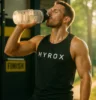 Athlete drinking water from a reusable bottle in the gym or on a trail, sunlit and energised