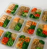 Organised containers of colourful, balanced meals lean protein, complex carbs, vegetables on a clean kitchen counter