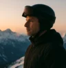 A serene portrait of a former Olympic skier gazing across a snowy mountain range at sunrise