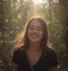 young woman, smiling, enjoying walk in nature, sundappled, enjoying the moment