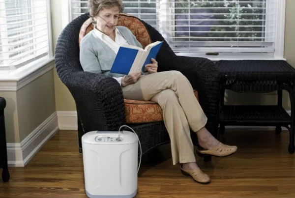 Senior woman reading while using a portable oxygen concentrator