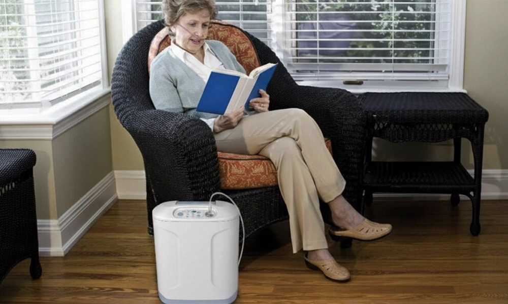 Senior woman reading while using a portable oxygen concentrator