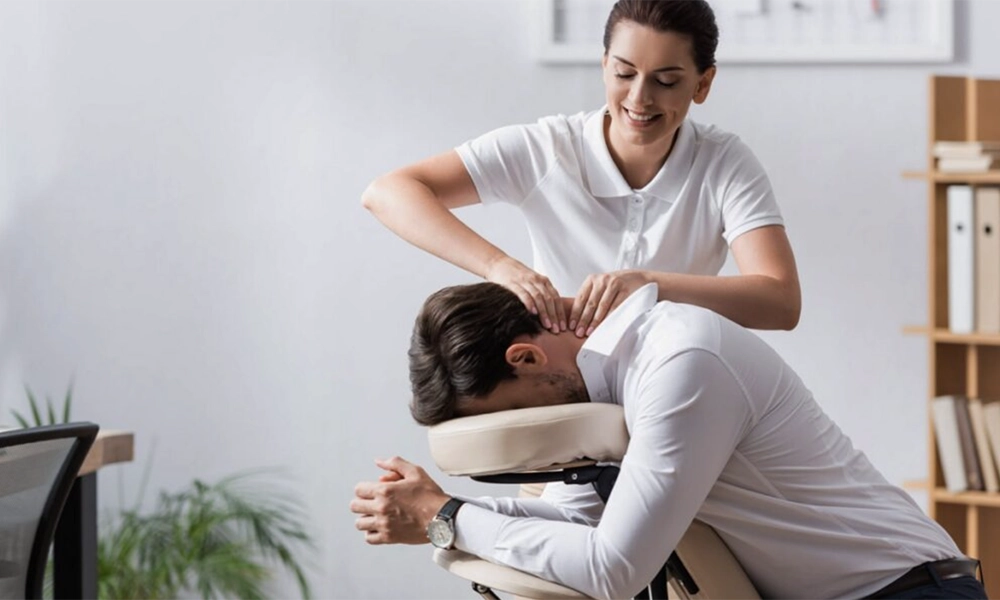 Professional massage therapist giving neck massage to man