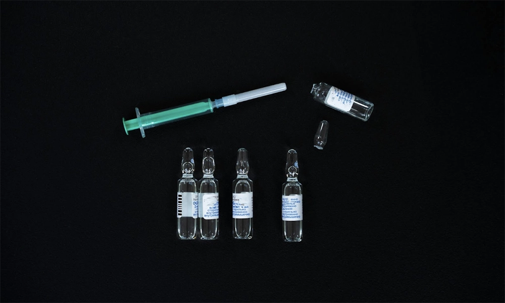 Five vials and a syringe, courtesy of Mikhail on Pexels