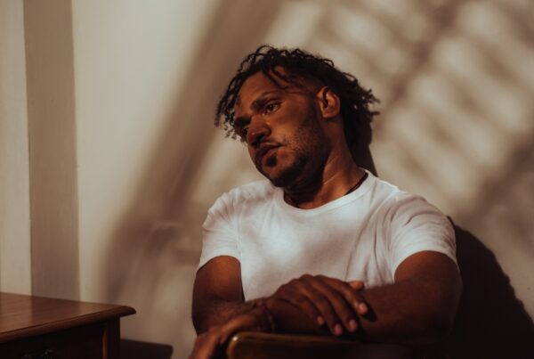 Lonely looking man sitting inside, with distant look in his eyes